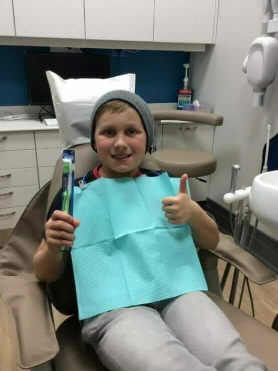 kid receiving toothbrush after cleaning